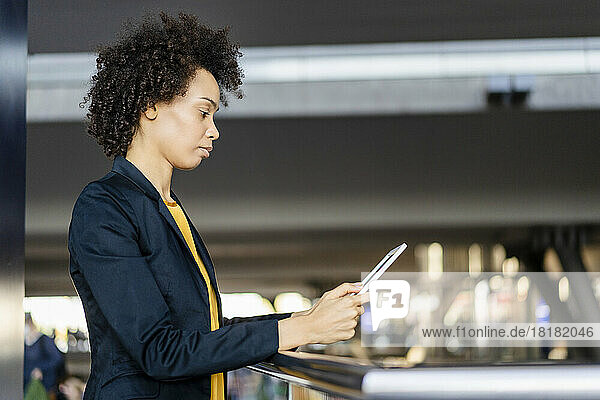 Businesswoman using tablet PC at railing