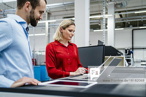 Business colleagues reviewing document at factory
