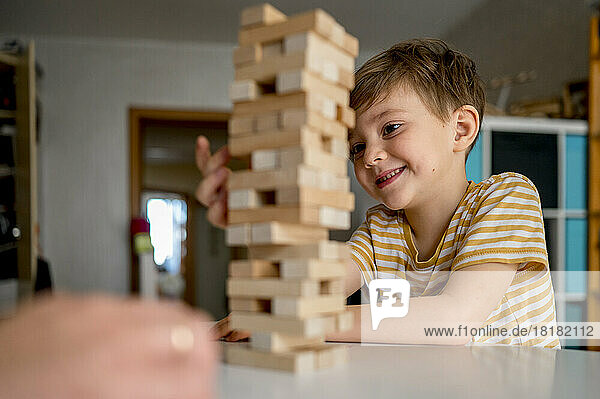 Smiling boy playing block removal game at home