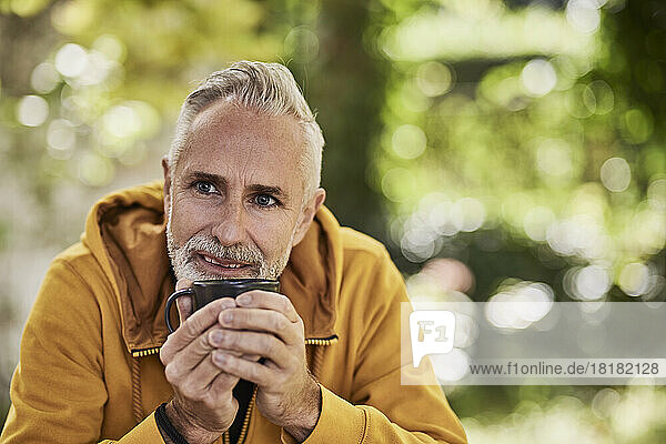 Contemplative mature man sitting with coffee cup