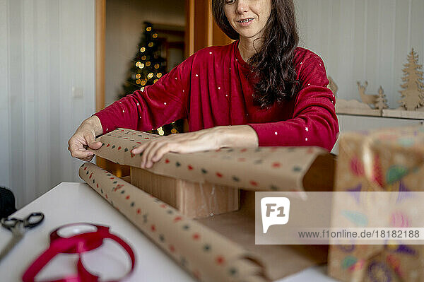 Woman wrapping Christmas presents at home