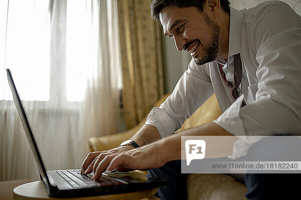 Happy businessman working on laptop from home
