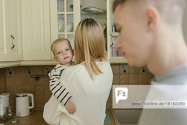 Boy with mother and father in kitchen at home