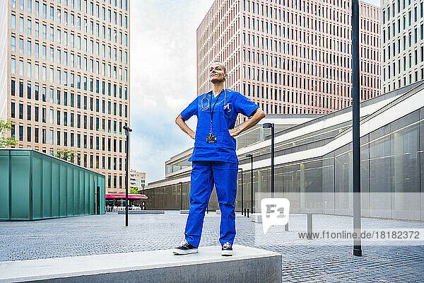 Selbstbewusste Krankenschwester steht mit den Händen auf den Hüften in der Stadt