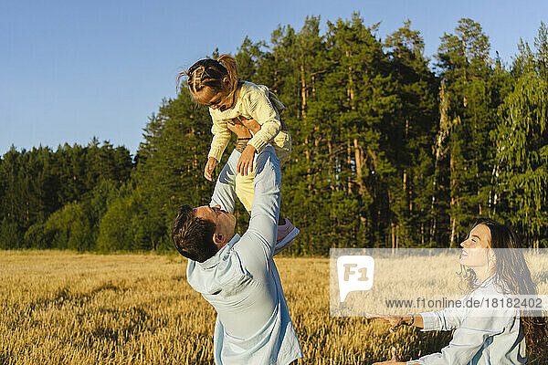 Playful parents having fun with daughter in field