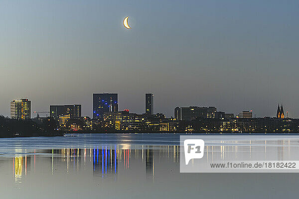 Germany  Hamburg  Moon rises over Outer Alster Lake with city skyline in background