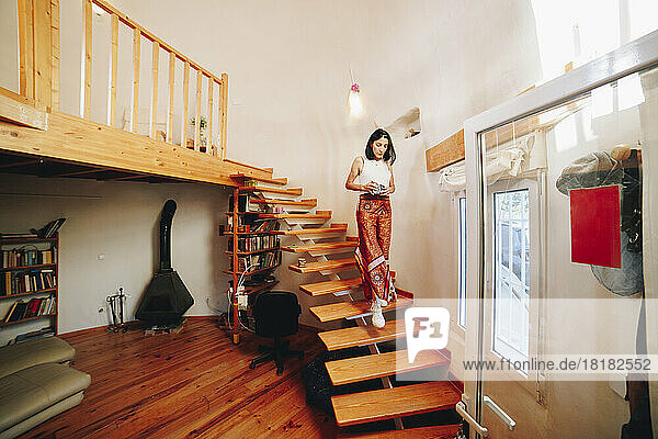 Mature woman moving down stairs at home