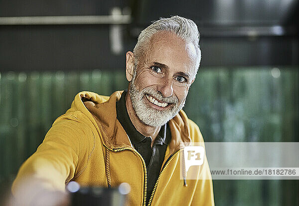 Happy mature man wearing yellow hooded shirt
