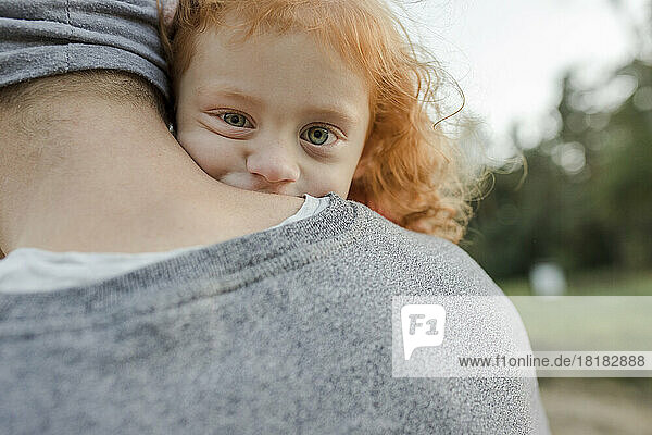 Father carrying redheaded daughter with green eyes