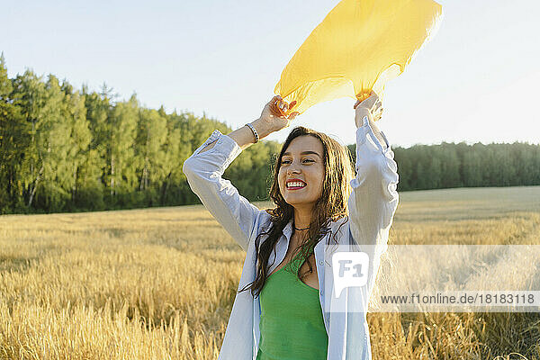 Happy woman with garbage bag standing on field