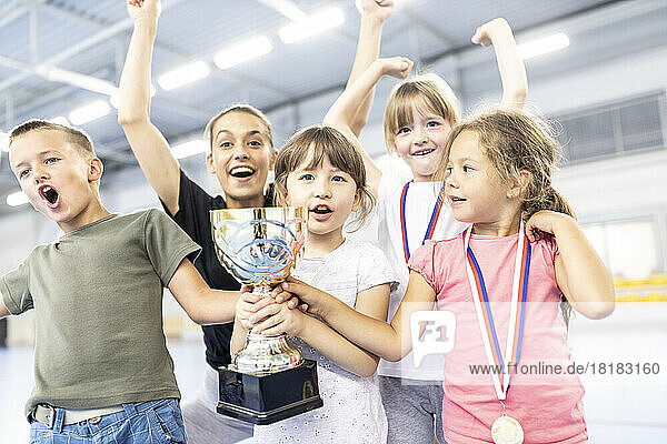 Fröhliche Schüler feiern Sieg mit Lehrer am Schulsportplatz