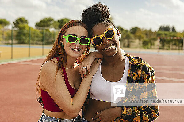 Young women wearing sunglasses standing in sports court