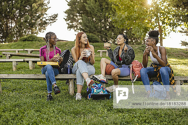 Young friends enjoying eating food at park
