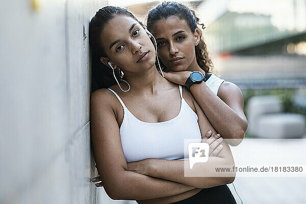 Teenage girl leaning on wall with friend