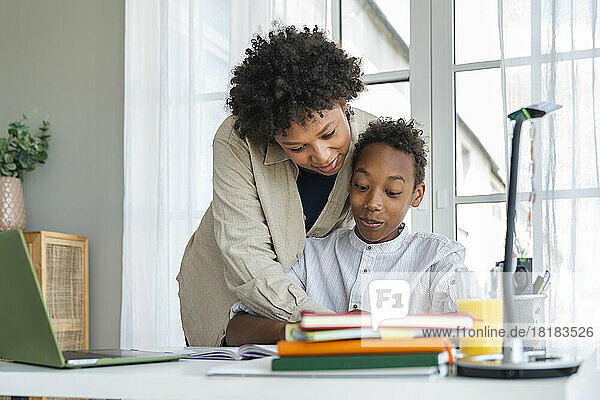 Mother helping son in homework at home