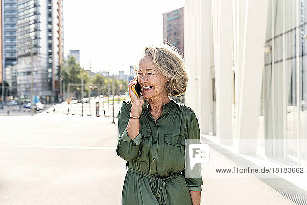 Smiling mature woman talking on smart phone