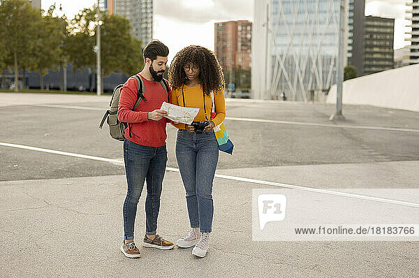 Young couple discussing over map at footpath
