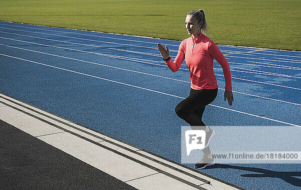 Athlete doing warm up exercise on running track