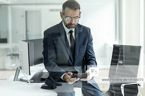 Businessman using tablet PC sitting on table in office