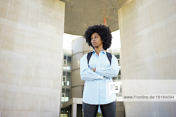 Confident young businesswoman standing outside office building