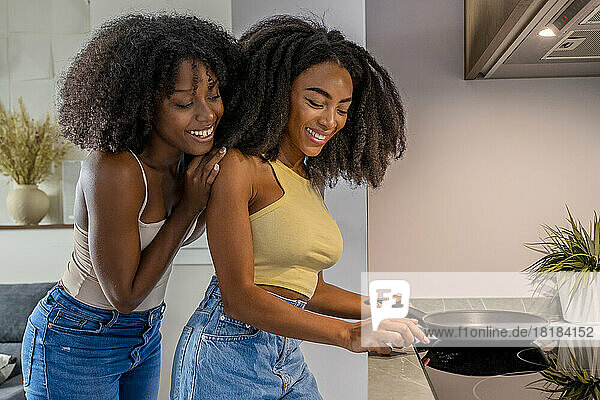 Smiling lesbian couple cooking together in kitchen