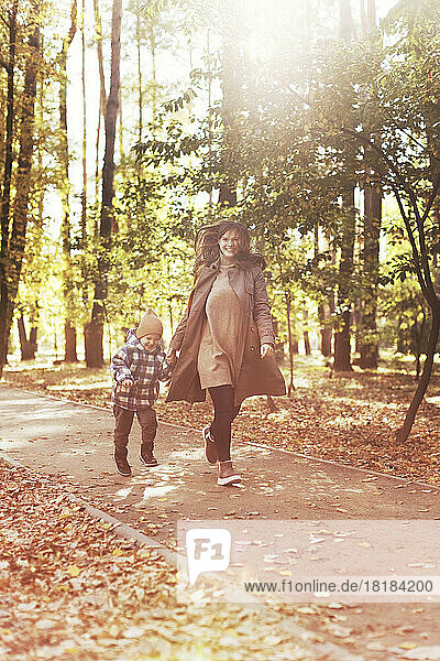 Mother and son running together in park