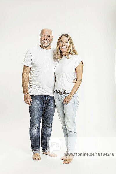 Smiling couple standing together against white background