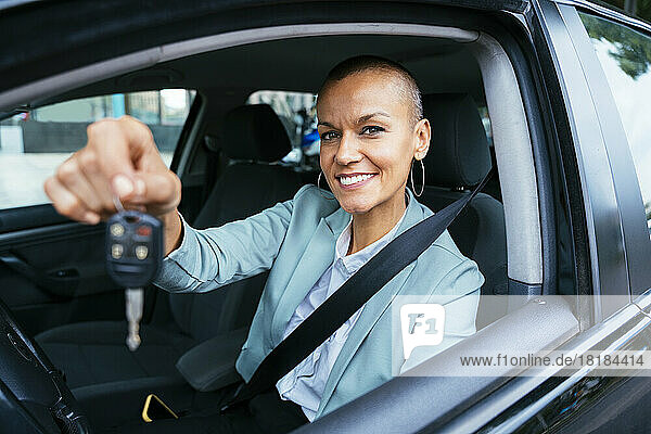 Smiling businesswoman showing car key