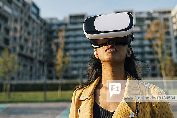 Junge Frau trägt an einem sonnigen Tag einen Virtual-Reality-Simulator