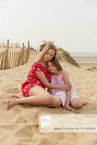 Two girls hugging on the beach