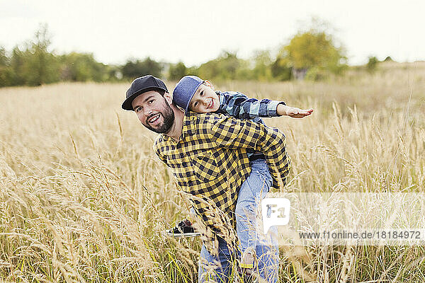 Vater und süßer Junge haben Spaß auf dem Feld