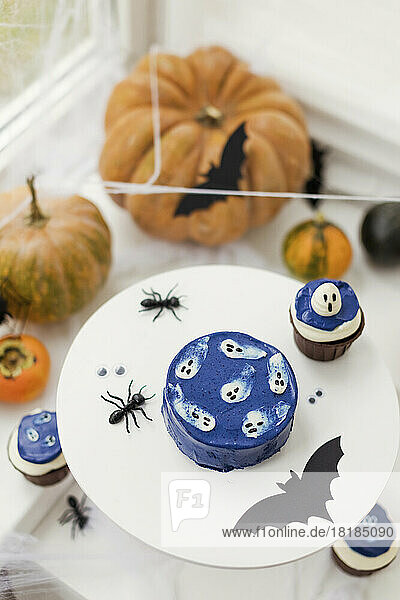 Kürbisse mit Kuchen und Halloween-Dekoration auf dem heimischen Tisch