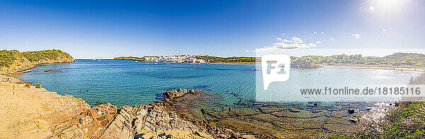Spanien  Balearen  Menorca  Panoramablick auf die Bucht im Sommer mit einem Dorf im Hintergrund