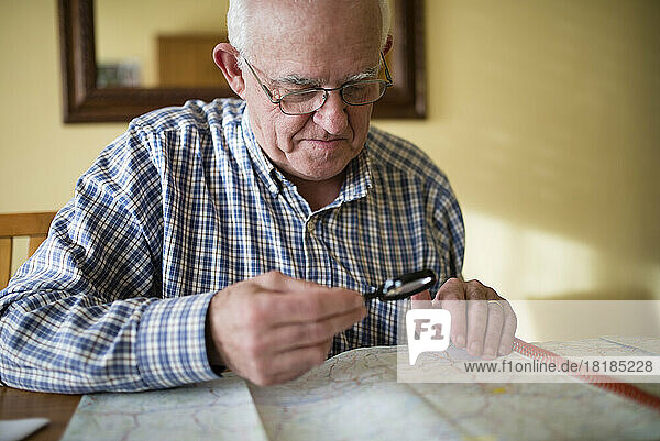 Senior man looking at a road map using magnifier