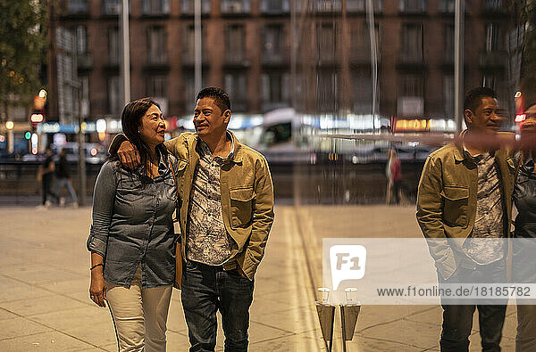 Lächelndes älteres Paar  das nachts auf dem Fußweg spaziert