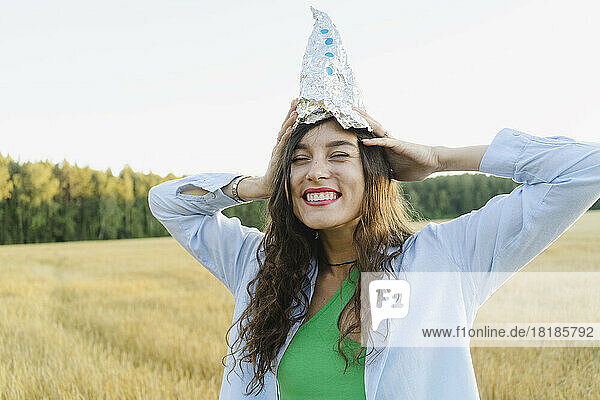 Woman with homemade toy rocket on head at field