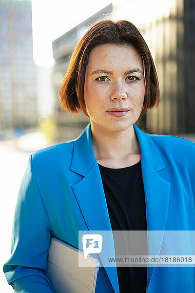 Businesswoman wearing blue blazer holding tablet PC