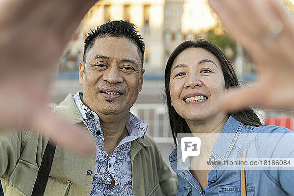 Smiling mature couple making finger frame