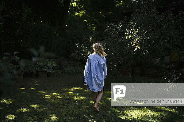 Woman in over sized shirt walking at garden