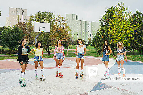 Smiling friends standing together at basketball court