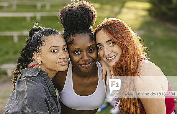 Happy young women standing together in park