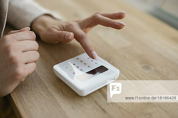 Hand of businesswoman using credit card reader on table