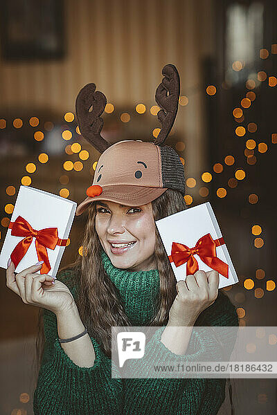 Happy woman holding Christmas gifts at home