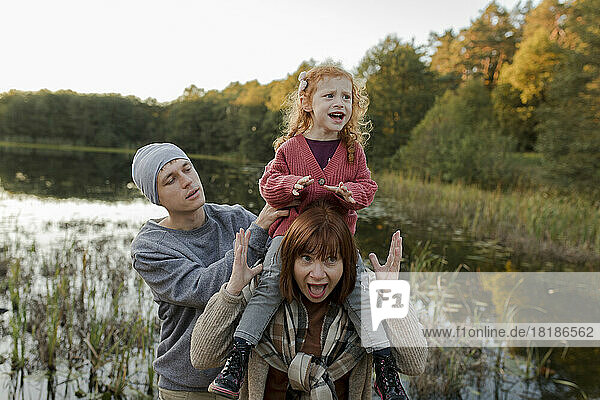 Playful family enjoying together near lake