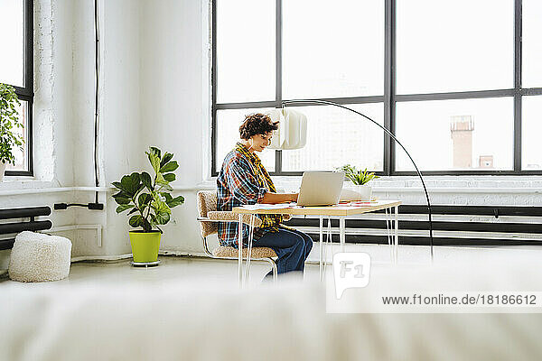 Illustrator working at desk in front of window at office
