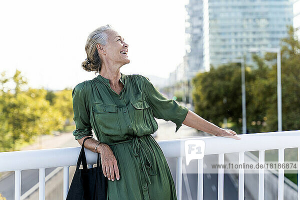 Happy woman leaning on railing
