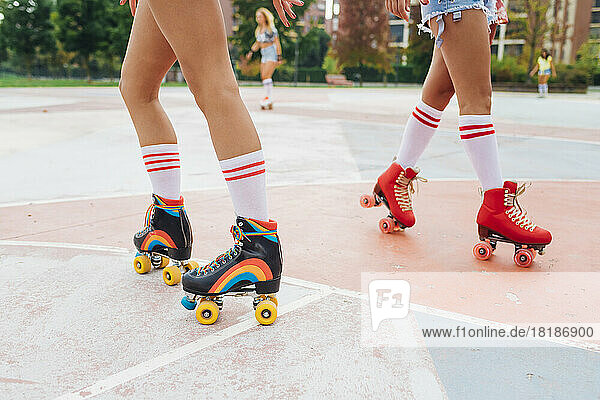 Woman with friends roller skating at sports court