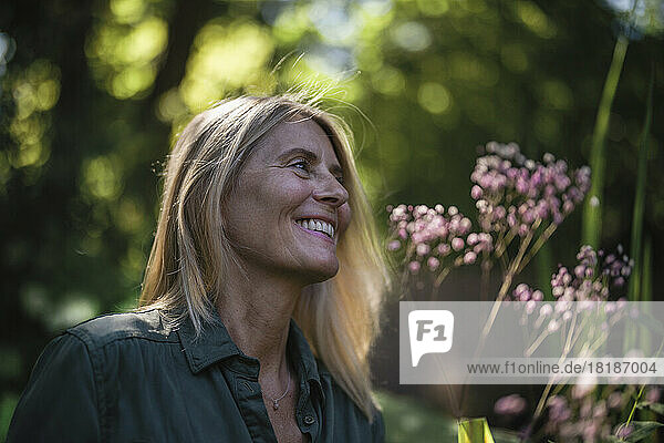 Happy mature woman with blond hair in garden