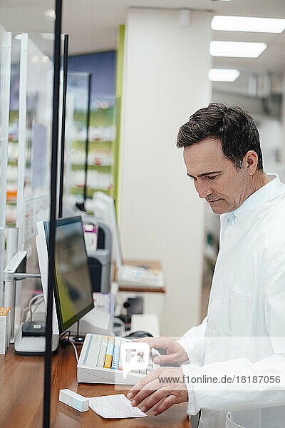 Pharmacist analyzing prescription medicine at store