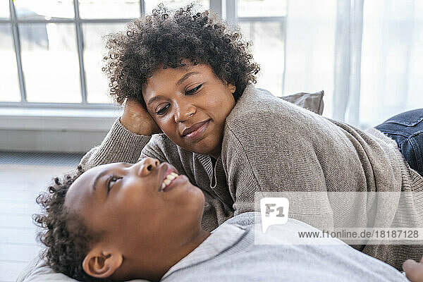 Mother looking at son lying down at home